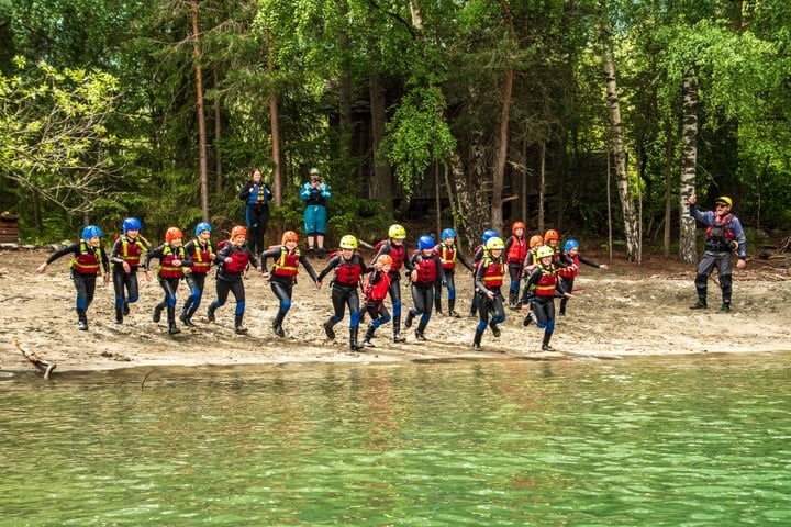 Barn svømmer og leker i Gudbrandsdalslågen på sommerleir i Sjoa.